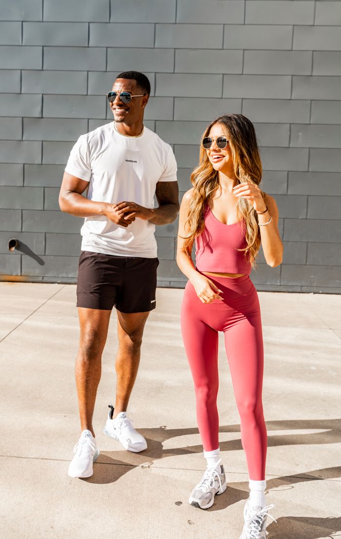 A man and woman in sportswear enjoying a sunny day outdoors, embracing an active and healthy lifestyle.